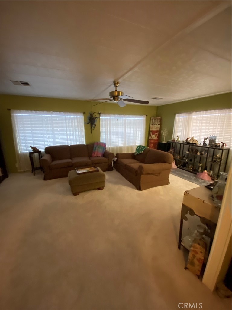 12680 4th Street, Unit 39 Yucaipa, CA 92399 - Photo 12 of 45 a living room with furniture a large window and a chandelier