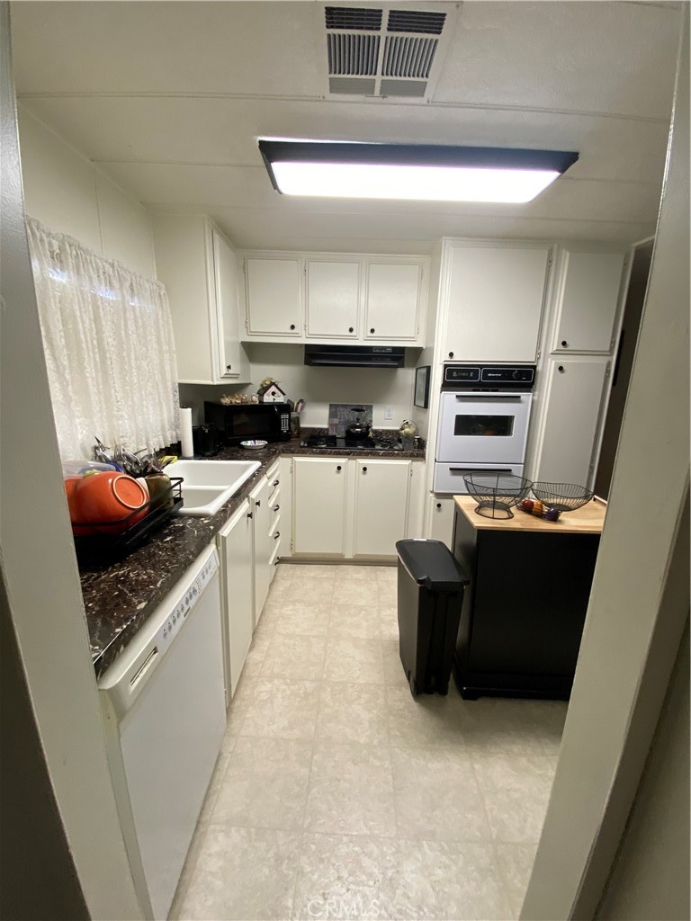 12680 4th Street, Unit 39 Yucaipa, CA 92399 - Photo 16 of 45 a kitchen with stainless steel appliances kitchen island granite countertop a refrigerator and a stove top oven