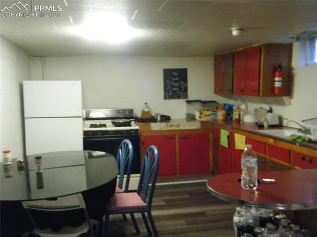 a kitchen with stainless steel appliances granite countertop a refrigerator a stove a sink dishwasher with a dining table and chair