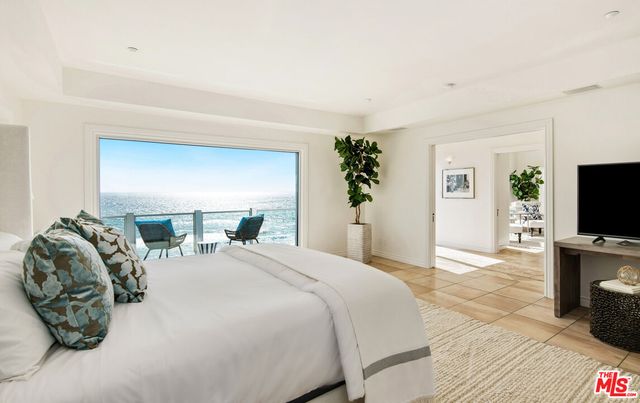 a spacious bedroom with a bed and large windows