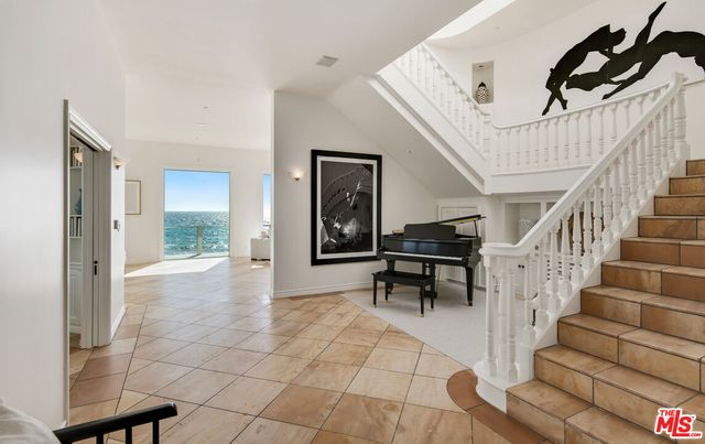 a living room with furniture kitchen view and a large window