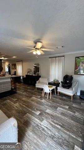 a living room with furniture and a dining table with kitchen view