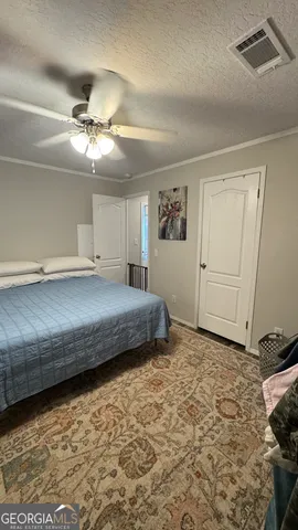 a bedroom with a bed and a ceiling fan