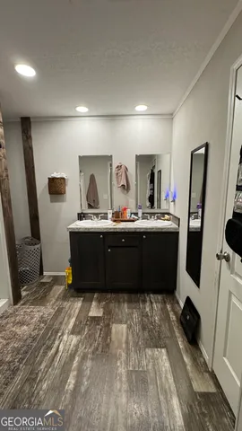 a room with a sink a mirror and window