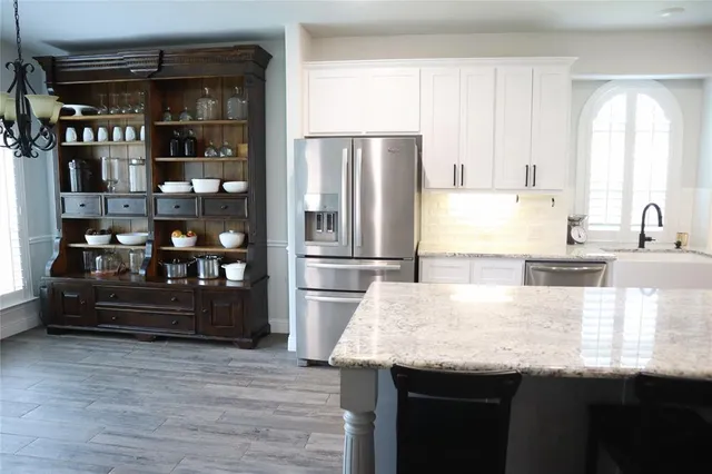 a kitchen with granite countertop cabinets stainless steel appliances and wooden floor