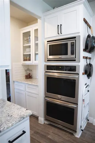 a kitchen with granite countertop a sink stainless steel appliances and cabinets