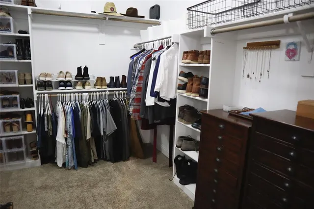 a view of walk in closet with clothes and shoes
