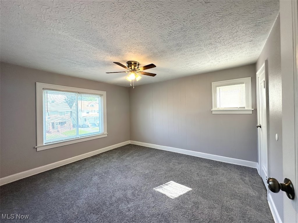 3288 Kildare Road Cleveland, OH 44118 - Photo 11 of 18 Empty room featuring dark carpet, a textured ceiling, and ceiling fan