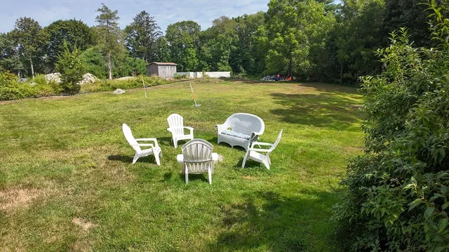 a view of a chairs and table in patio with a yard