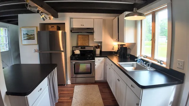 a kitchen with a table chairs and wooden floor