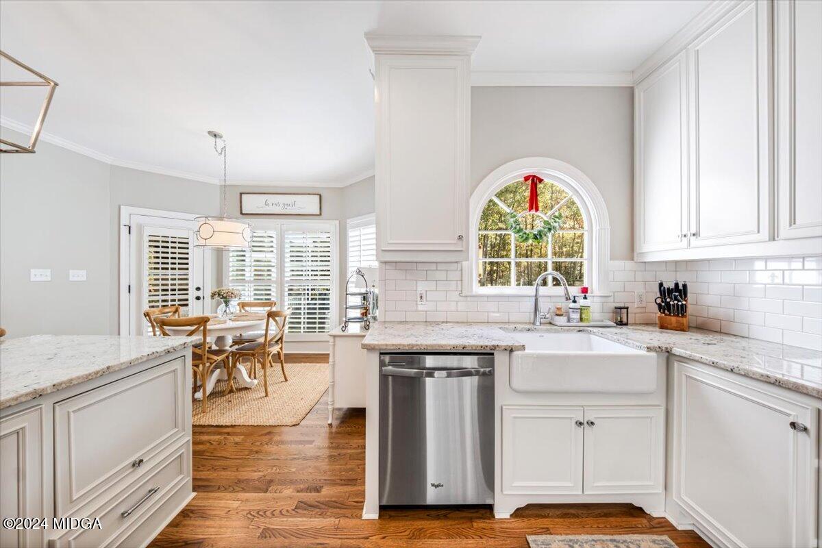 7701 Whittle Road Macon, GA 31220 - Photo 12 of 56 a kitchen with a stove a sink a dining table and chairs with wooden floor