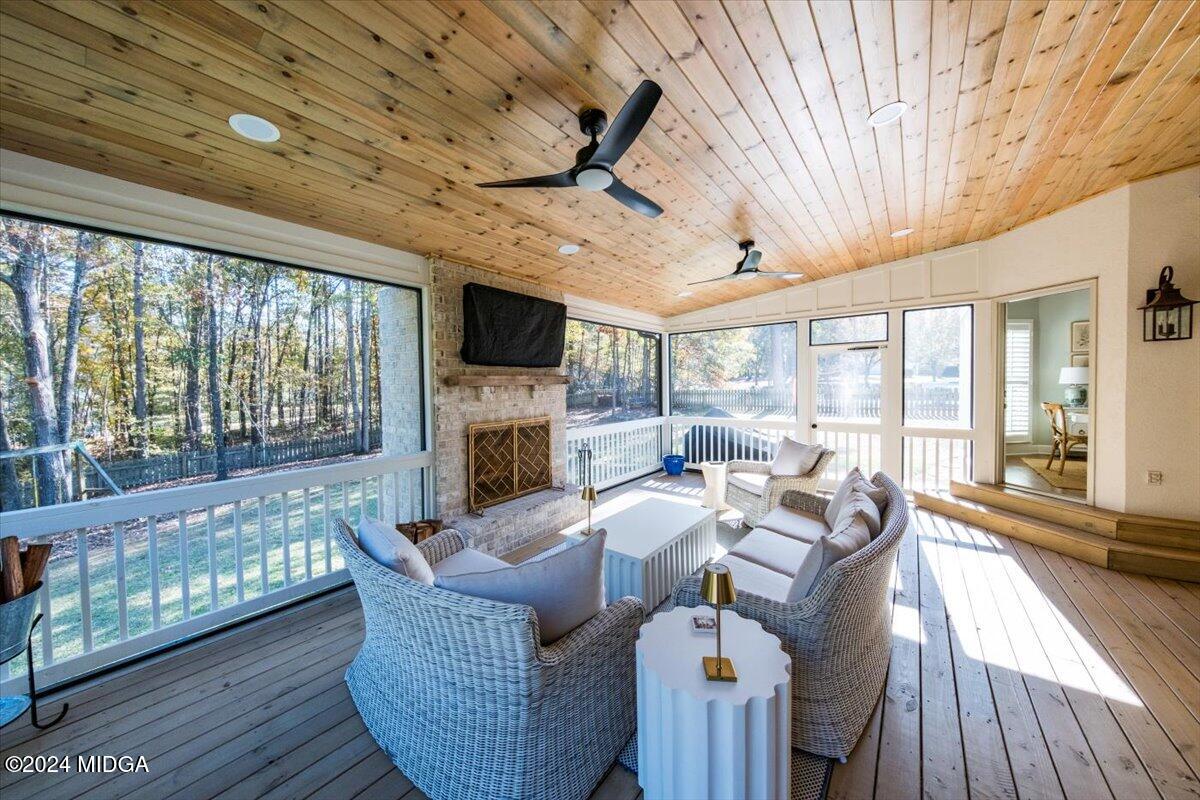 7701 Whittle Road Macon, GA 31220 - Photo 41 of 56 a living room with furniture a fireplace and a floor to ceiling window