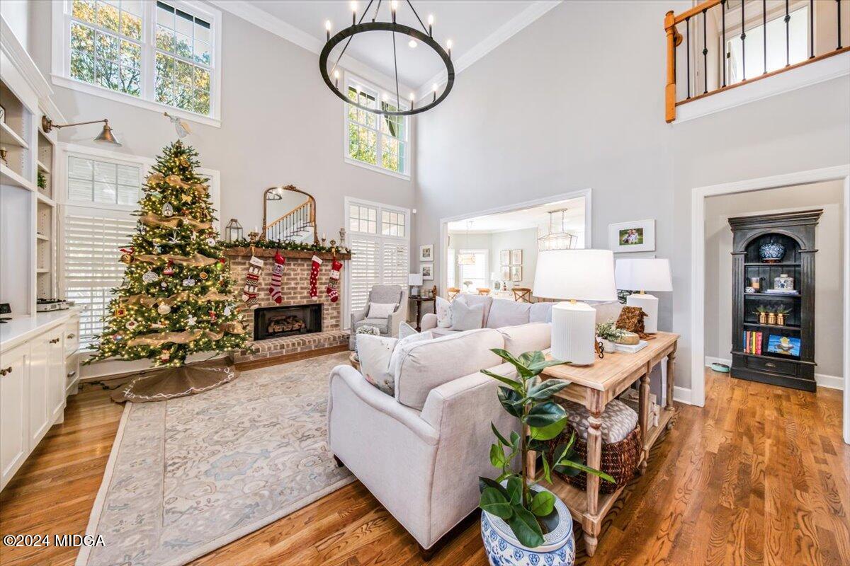 7701 Whittle Road Macon, GA 31220 - Photo 7 of 56 a living room with furniture a chandelier and a fireplace
