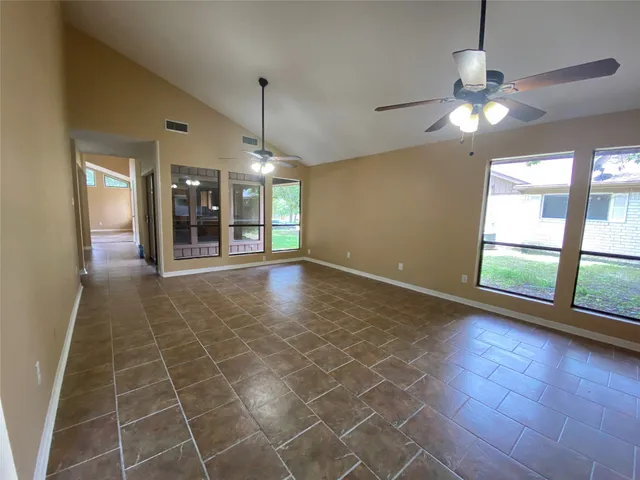 a view of an empty room with a fireplace and a window