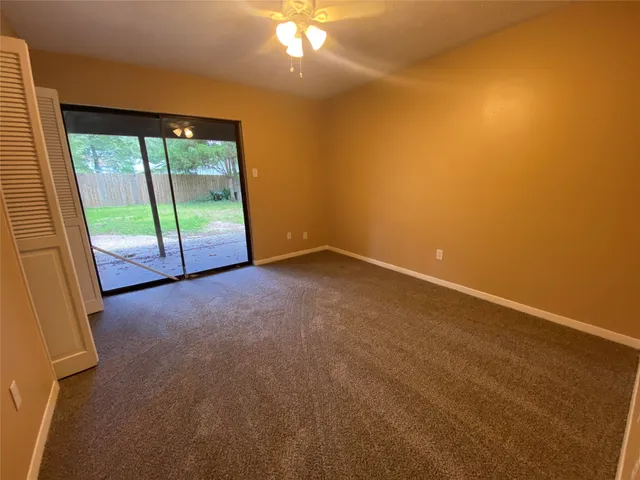 a view of an empty room with window chandelier fan