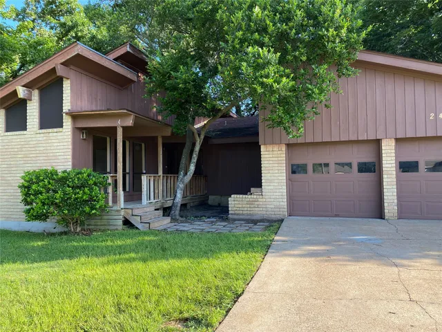 a front view of a house with a yard and trees