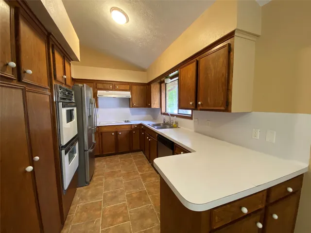 a kitchen with stainless steel appliances a sink stove and refrigerator