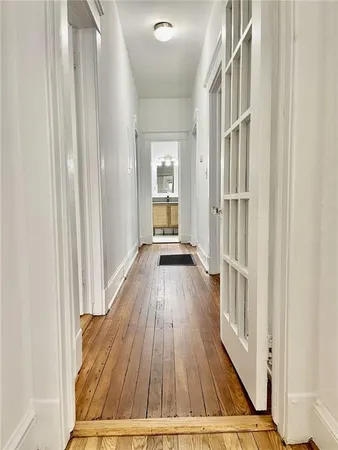 a view of a hallway with wooden floor and staircase