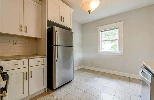 a kitchen with white cabinets and white appliances