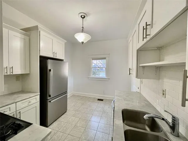 a kitchen with stainless steel appliances granite countertop a refrigerator a stove and a sink with wooden floor