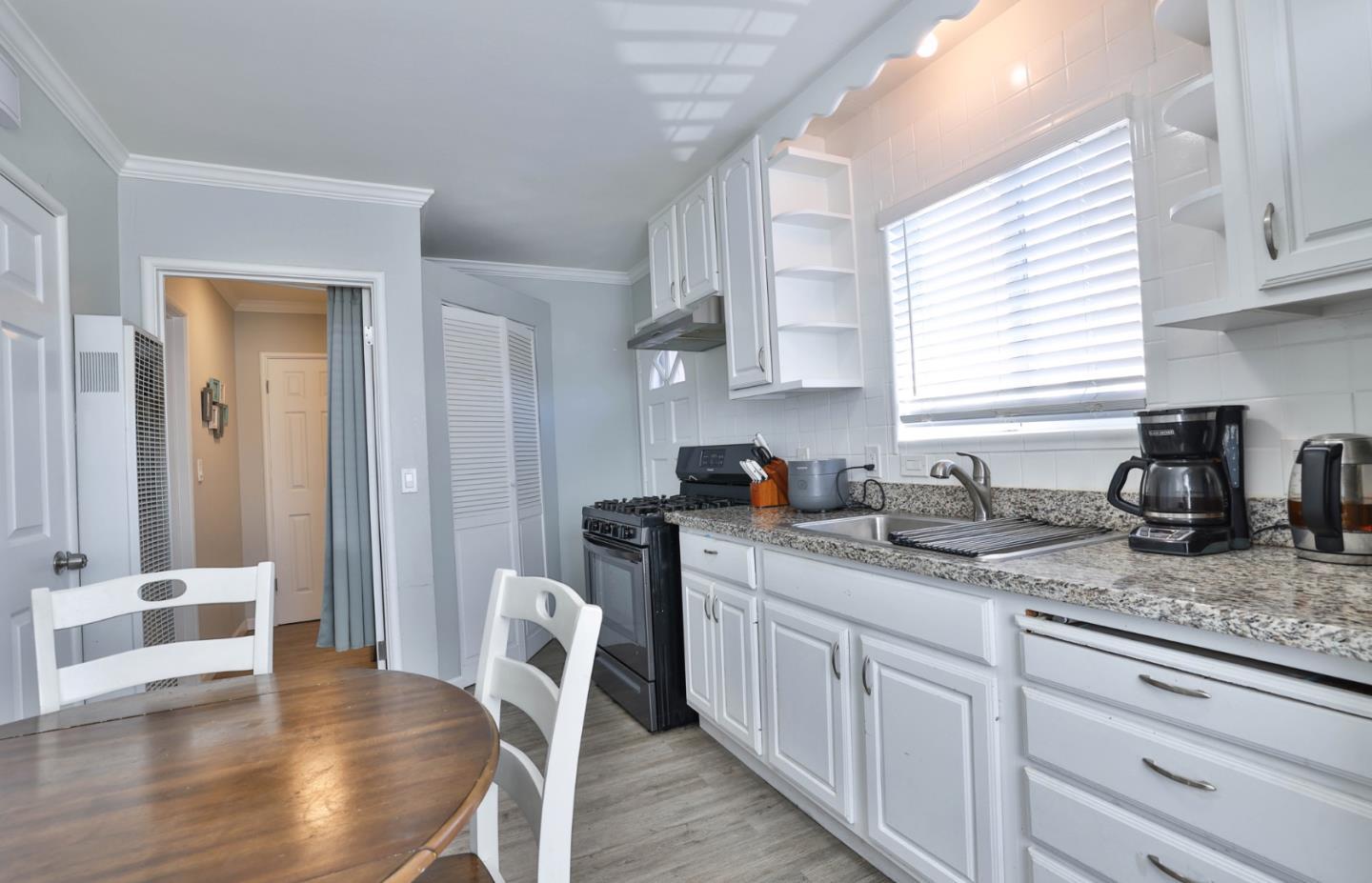 1431 Dwight Way Berkeley, CA 94702 - Photo 9 of 21 a kitchen with stainless steel appliances granite countertop a sink a stove a dining table and chairs