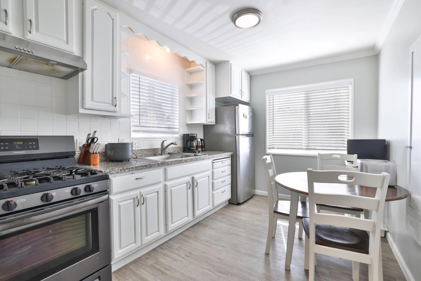 1431 Dwight Way Berkeley, CA 94702 - Photo 10 of 21 a kitchen with stainless steel appliances granite countertop a stove a sink dishwasher a refrigerator with white cabinets and wooden floor