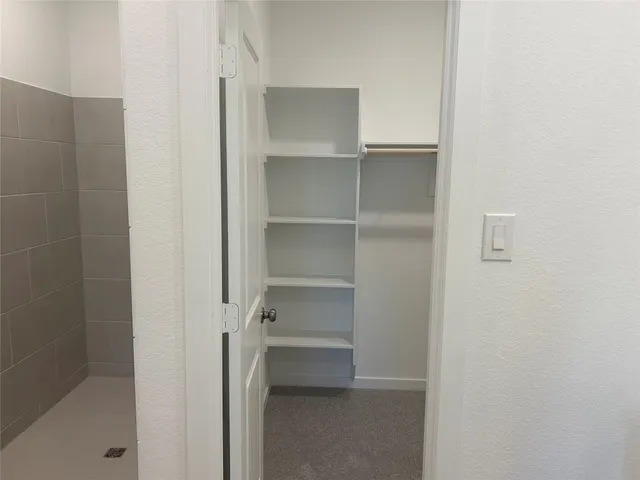 a view of walk in closet with empty racks