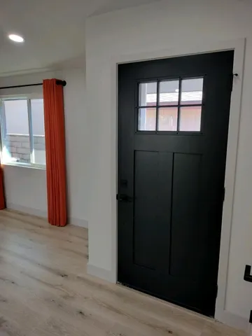 a view of an empty room with a window and wooden floor