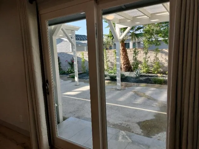 a kitchen with white cabinets and a large window