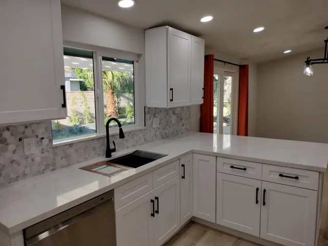 a kitchen with refrigerator a microwave and white cabinets