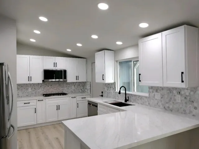 a kitchen with stainless steel appliances granite countertop a refrigerator and a stove top oven