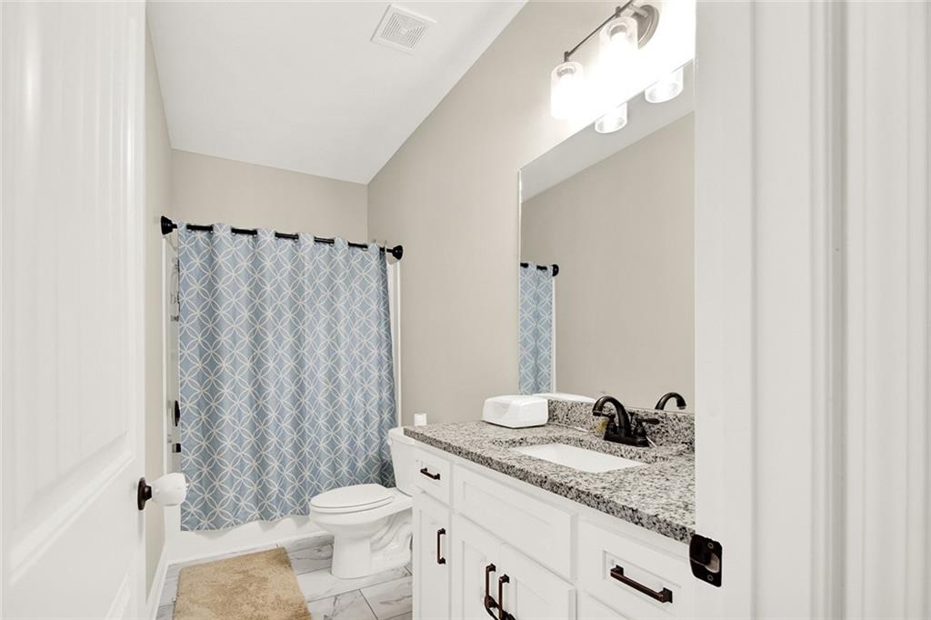 407 Corinth Church Road Winder, GA 30680 - Photo 52 of 66 a bathroom with a granite countertop sink toilet and shower