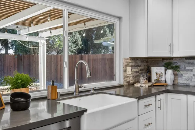 a kitchen with kitchen island granite countertop stainless steel appliances cabinets a sink and a counter top space