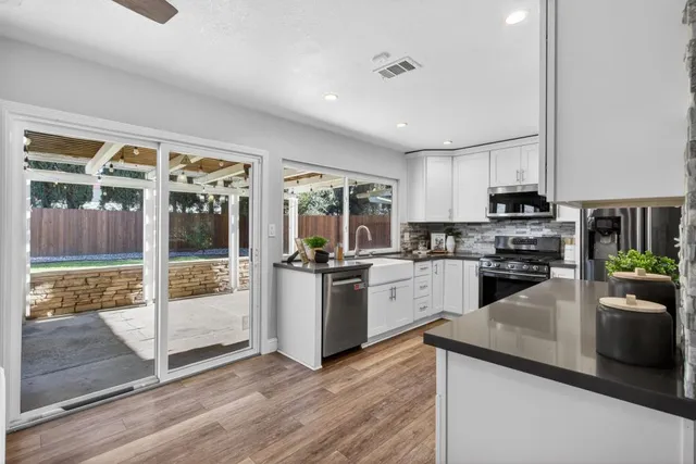 a kitchen with stainless steel appliances granite countertop a refrigerator and a stove top oven