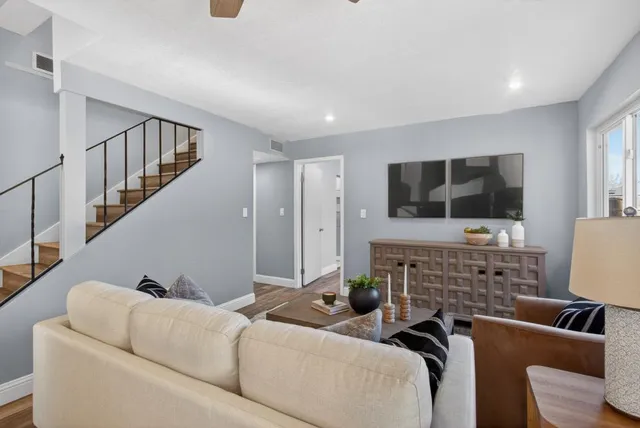 a living room with furniture a flat screen tv and a window