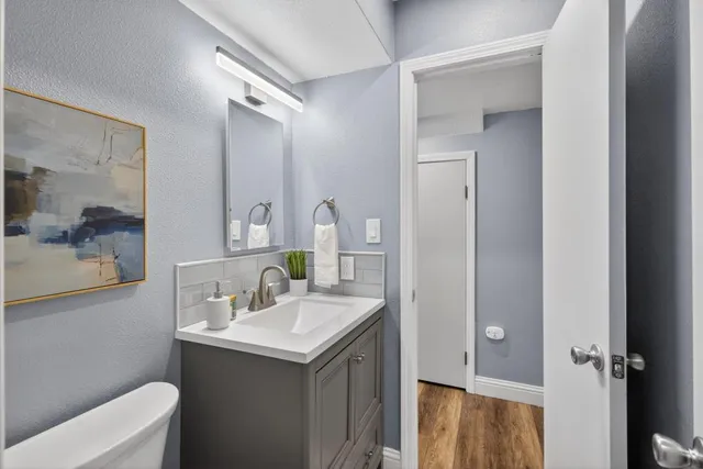 an empty room with wooden floor ceiling fan and windows