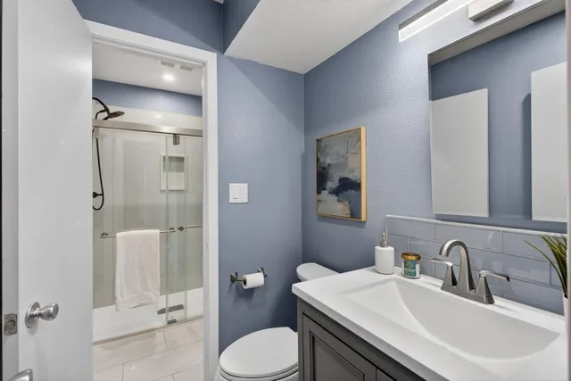 a bathroom with a granite countertop sink a mirror and a shower