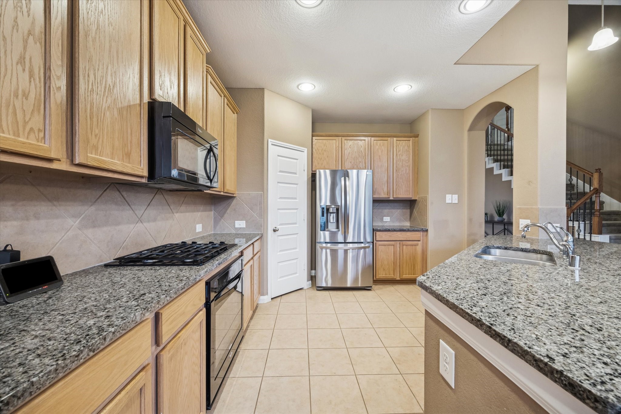7023 Sliding Rock Circle Spring, TX 77379 - Photo 12 of 39 a kitchen with stainless steel appliances granite countertop a stove a sink and a refrigerator