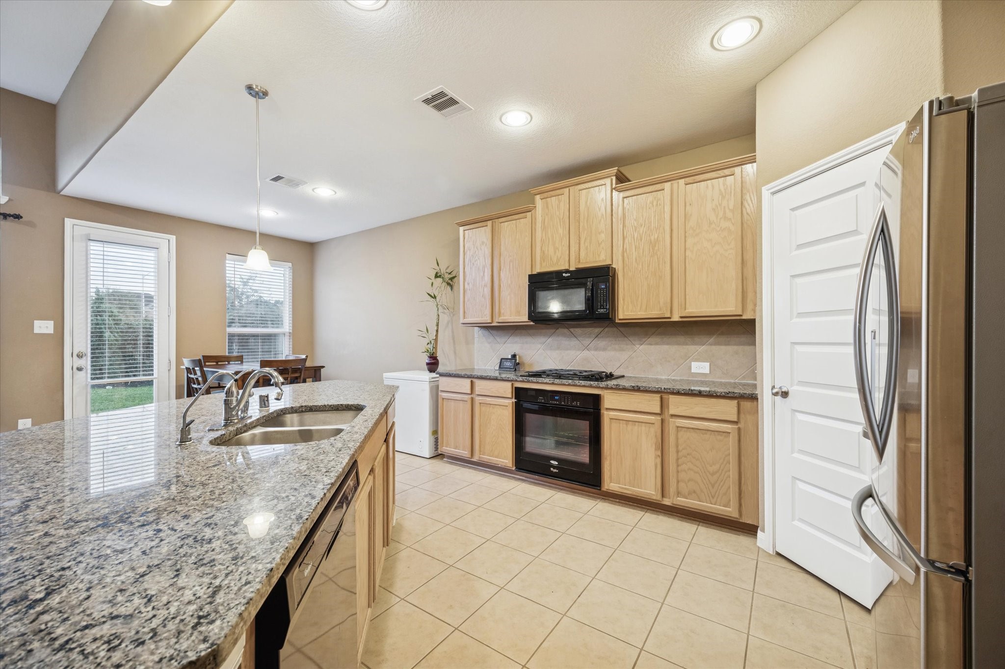 7023 Sliding Rock Circle Spring, TX 77379 - Photo 13 of 39 a kitchen with stainless steel appliances granite countertop a refrigerator and a stove top oven