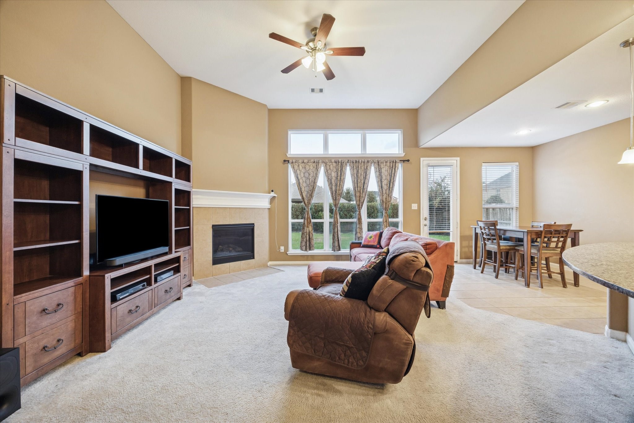 7023 Sliding Rock Circle Spring, TX 77379 - Photo 8 of 39 a living room with furniture a flat screen tv and a fireplace