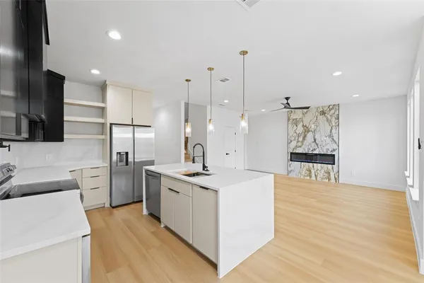 a kitchen with stainless steel appliances kitchen island granite countertop a sink a stove and a refrigerator