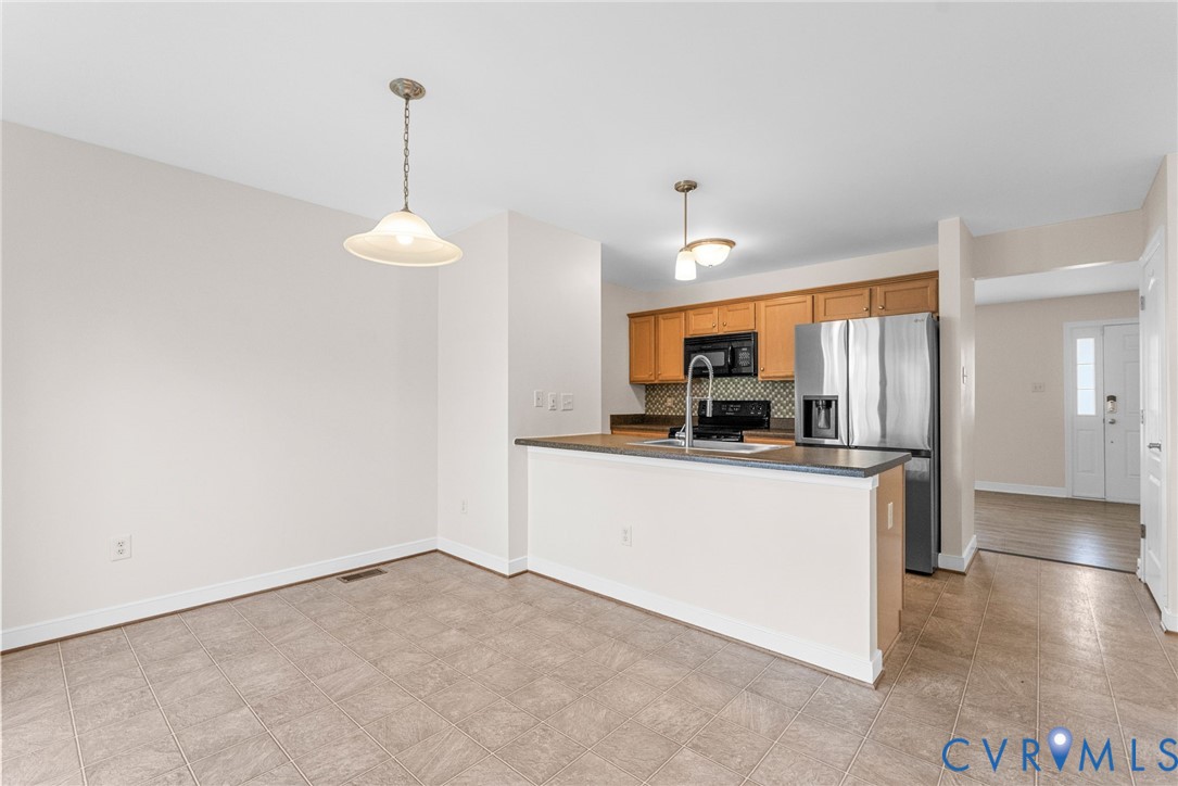 2110 Chaucer Court Aylett, VA 23009 - Photo 21 of 40 a kitchen with kitchen island a counter top space a sink a refrigerator and a view of living room