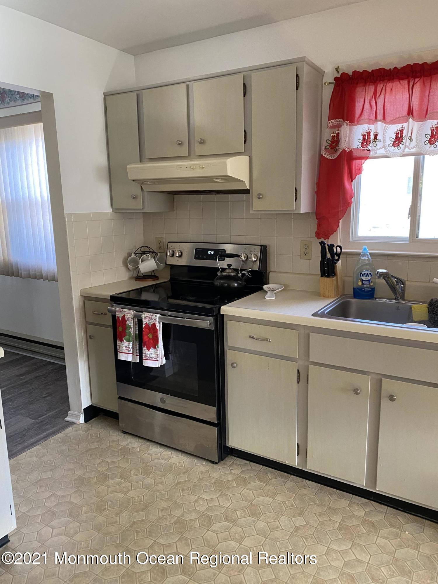 47 Augusta Road, Unit 73 Whiting, NJ 08759 - Photo 4 of 13 a kitchen with stainless steel appliances granite countertop a stove a sink and a microwave