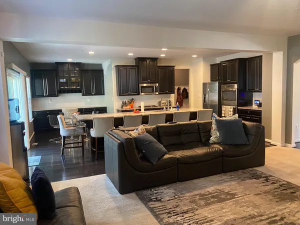 a living room with furniture kitchen view and a window