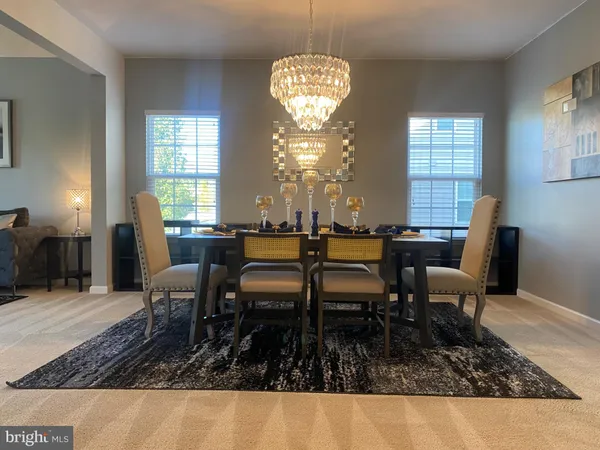 a dining room with wooden floor a chandelier a wooden table and chairs