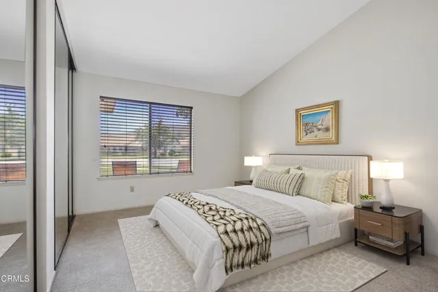 a bedroom with a bed and a large window