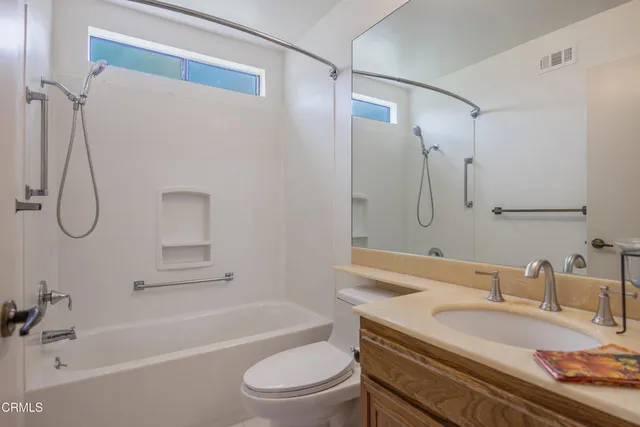 a bathroom with a granite countertop sink a toilet and shower