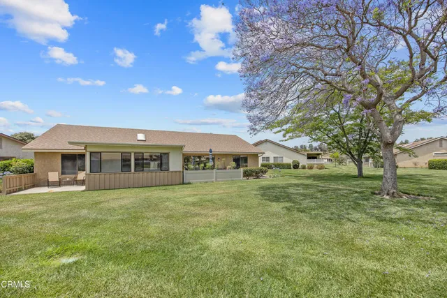 a view of a house with a big yard and large trees