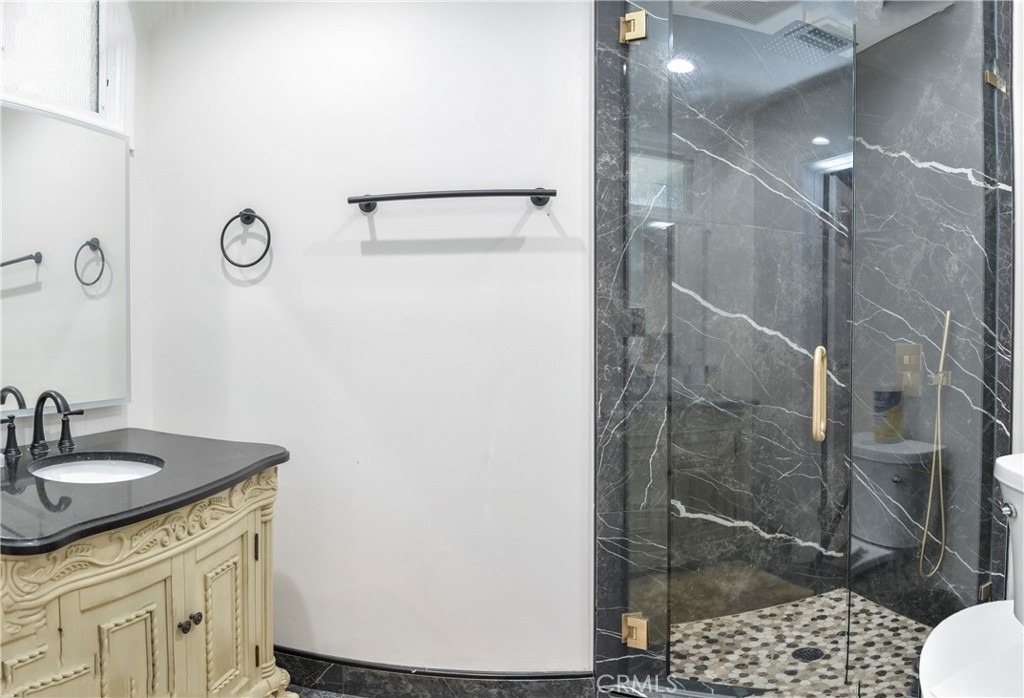 9728 Rhea Avenue Northridge, CA 91324 - Photo 21 of 36 a bathroom with a shower sink and mirror