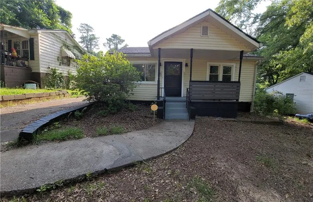 a view of a small house with a yard